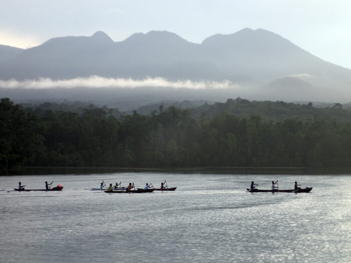 Community members in the Solomon Islands paddle in traditional boats off the coast. Credit: © Stacy Jupiter